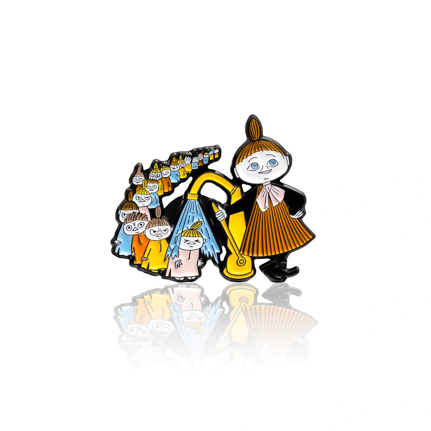 Emaliowana broszka z postacią Małej Mi w żółto-brązowej sukience trzymającej żółtą torbę, za nią grupa małych postaci Muminków w różnokolorowych strojach